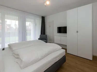 Schlafzimmer mit Doppelbett, Kleiderschrank und Flatscreen TV