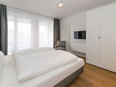 Schlafzimmer mit Doppelbett, Kleiderschrank und Flatscreen TV