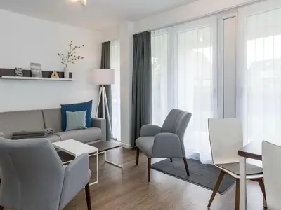 Wohn-Essbereich mit Couch und Zugang zur Terrasse
