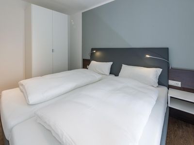 Schlafzimmer mit Doppelbett und Kleiderschrank