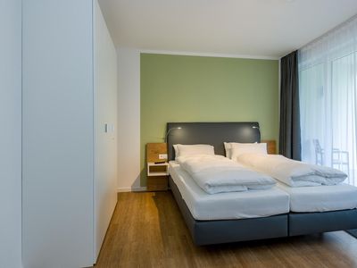 Schlafzimmer mit Doppelbett und Zugang zur Terrasse