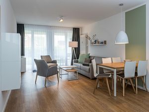 Wohn-Essbereich mit Couch, Esstisch, Sitzgelegenheit und Flatscreen TV