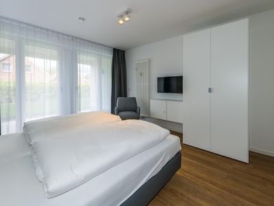 Schlafzimmer mit Doppelbett, Kleiderschrank und Flatscreen TV