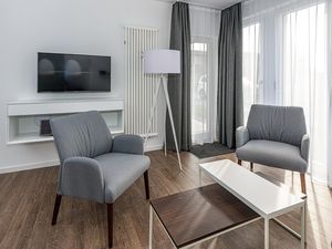 Wohn-Essbereich mit Flatscreen TV, Sitzgelegenheit und Zugang zur Terrasse