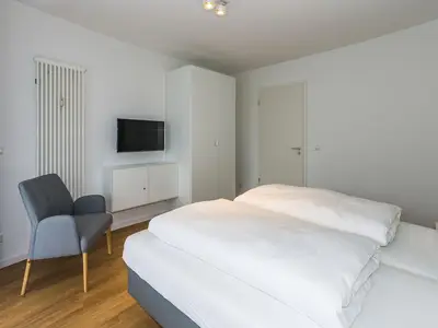 Schlafzimmer mit Doppelbett, Kleiderschrank und Flatscreen TV