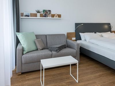 Wohn-Ess-Schlafbereich mit Sofa und Doppelbett