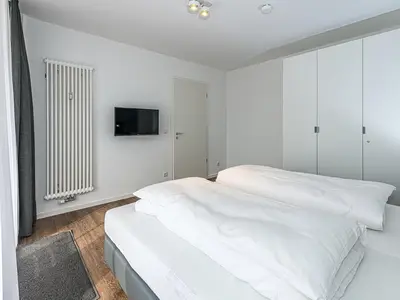 Schlafzimmer mit Doppelbett, Kleiderschrank und Flatscreen TV