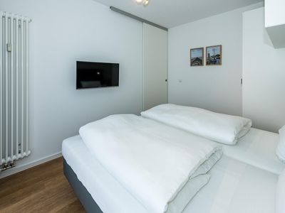 Schlafzimmer mit Doppelbett, Kleiderschrank und Flatscreen TV