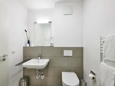 Badezimmer mit Waschtisch, Spiegel und WC