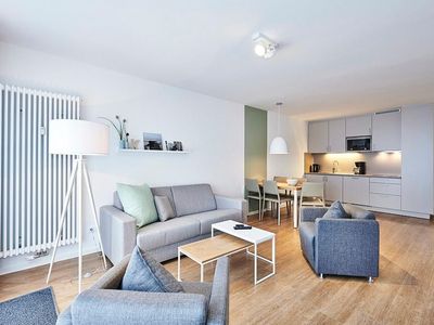 Wohnbereich mit Sofa, Sitzgelegenheit und Küchenzeile