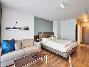 Wohn-Schlafbereich mit Couch und Doppelbett