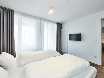 Schlafzimmer mit Doppelbett und TV