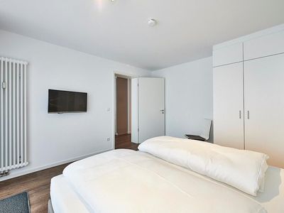 Schlafzimmer mit Doppelbett, Kleiderschrank und TV