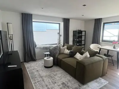 Wohnzimmer mit Couch mit Flach-TV und Essplatz