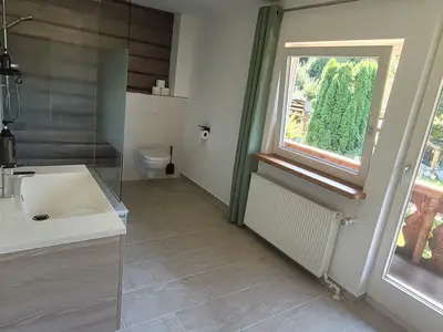 Badezimmer mit Zugang zum Balkon