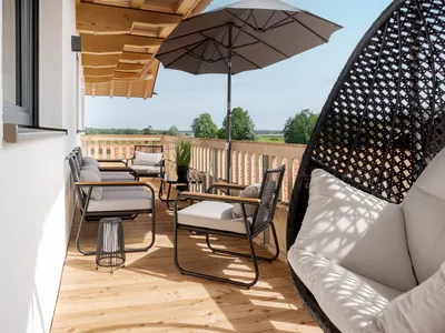 Der geräumige Balkon bietet mit Loungemöbeln, Hängesessel und Liegestühlen  genügend Sitzgelegenheiten im Freien an