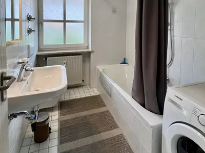 Badezimmer mit Duschwanne und Waschmaschine
