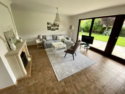 Zum Flur hin offenes Wohnzimmer mit Blick auf Garten und Berge