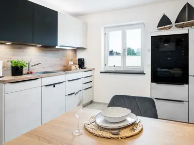 Kühlgefrierkombination, Backofen, Spülmaschine und eine Kaffeemaschine.