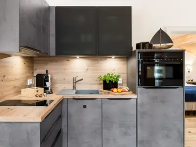 Kühlgefrierkombination, Backofen, Spülmaschine und eine Kaffeemaschine.