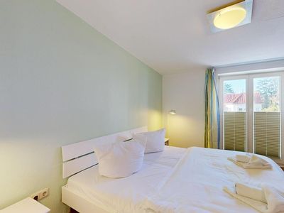 Doppelbett-Schlafzimmer mit Balkonzugang und TV