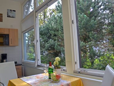 Essplatz mit großen Schiebefenstern auf der Veranda mit Gartenblick