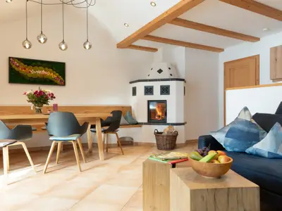 großzügiger Wohnraum mit Kachelofen Essecke und Couch