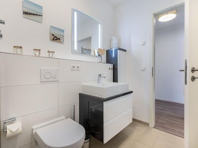 Badezimmer mit Waschtisch, Spiegel und WC
