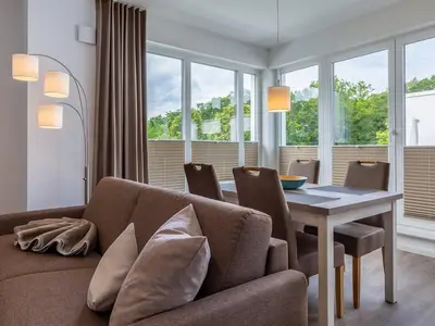 Wohn-/Essbereich mit Esstisch, Sitzgelegenheiten und Zugang zur Dachterrasse
