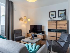 Wohnbereich mit Doppelschlafcouch, Couchtisch, Sessel und TV
