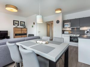 Wohn-/Essbereich mit Esstisch, Sitzgelegenheiten und Küchenzeile
