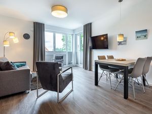 Wohn-/Essbereich mit Doppelschlafcouch, TV, Esstisch und Sitzgelegenheiten