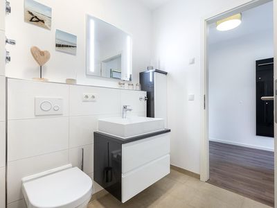 Badezimmer mit Waschtisch, WC und Zugang zum Flur