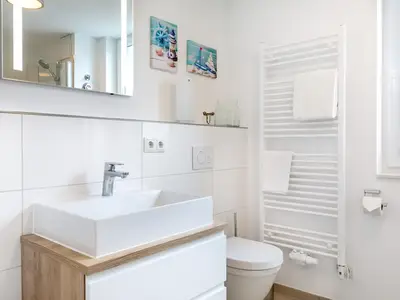 Badezimmer mit Waschtisch, Spiegel und WC