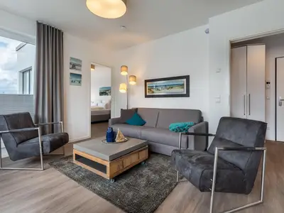 Wohnbereich mit Doppelschlafcouch, Couchtisch und Sessel