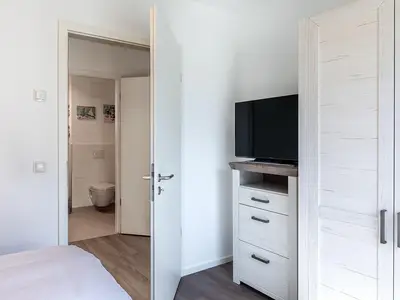Schlafzimmer mit Kleiderschrank und TV