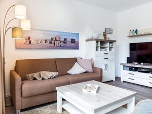 Wohn-/Essbereich mit Doppelschlafcouch, Couchtisch und TV