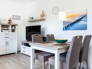 Wohn-/Essbereich mit Tisch, Sitzgelegenheiten und TV