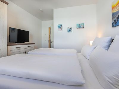 Schlafzimmer mit Doppelbett, Kleiderschrank und TV
