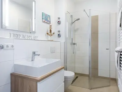 Badezimmer mit Dusche, Waschtisch, Spiegel und WC