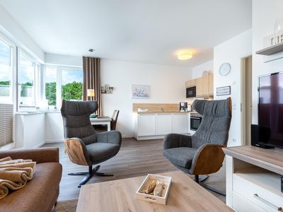 Wohn-/Essbereich mit Couchtisch, Sitzgelegenheiten und Küchenzeile