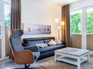 Wohn-/Essbereich mit Doppelschlafcouch, Couchtisch und Sessel
