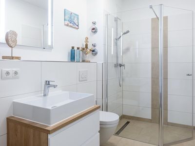 Badezimmer mit Dusche, Waschtisch, Spiegel und WC