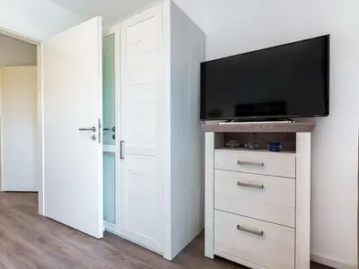 Schlafzimmer mit Kleiderschrank und TV