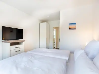 Schlafzimmer "1" mit Boxspringbett, TV und Blick zum Flur