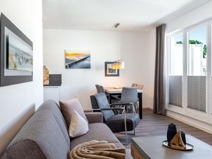 Wohn-/Essbereich mit Doppelschlafcouch und Zugang zur Dachterrasse