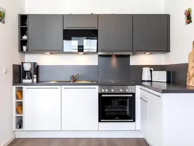 Offene Küche mit Backofen, Geschirspüler und Mikrowelle