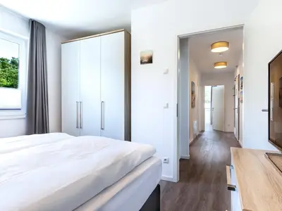 Schlafzimmer "1" mit Boxspringbett, TV und Blick zum Flur