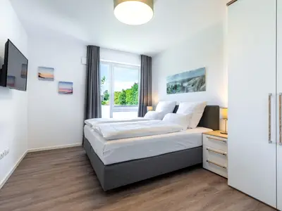 Schlafzimmer mit Boxspringbett, TV und Kleiderschrank