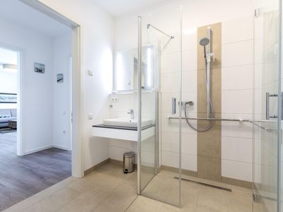 Badezimmer mit Dusche und Blick zum Wohn-/Essbereich